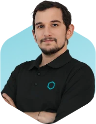 Dr. Rashed Hussain Mahboubi wearing a black polo with arms crossed on a turquoise background