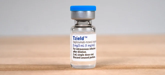 Small vial of Tzield injection medication on a wooden surface